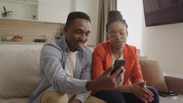 African American Couple Having a Conversation Via a Video Call on the Smart Phone with Their Friends