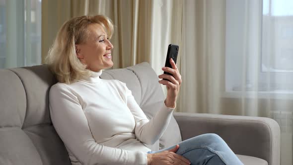 Mature Woman Communicates Via Videocall Using Smartphone
