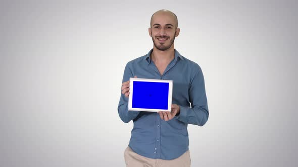 Arab Man Walking and Showing Tablet Presenting Something on Gradient Background.