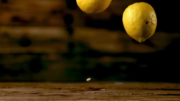 Super Slow Motion Fresh Lemons Fall on the Wooden Table