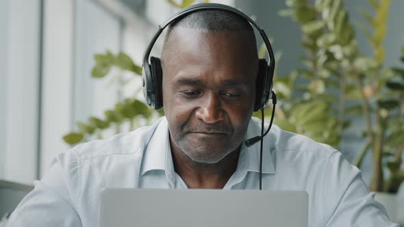 Concentrated African American Senior Entrepreneur Businessman Freelance Worker Wears Headphones with