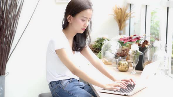 Beautiful young asian woman working online laptop with smile and happy sitting at cafe shop.