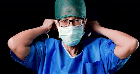 Female Surgeon Fastens the Mask