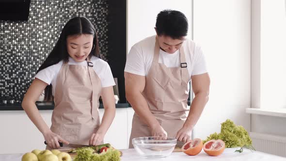 Portrait of Happy Young Asian Couple Cooking Together in the Kitchen at Home
