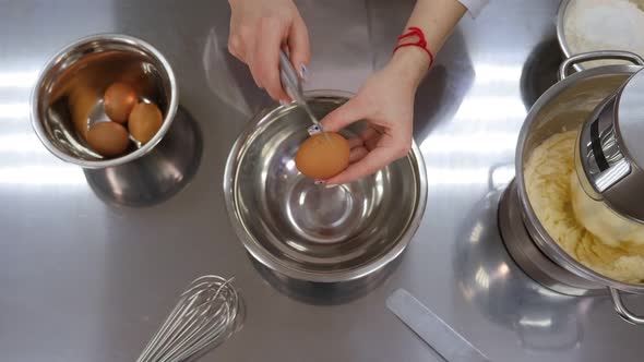 The Woman-the Cook Breaks the Eggs Into a Bowl To Make the Batter for the Cake.