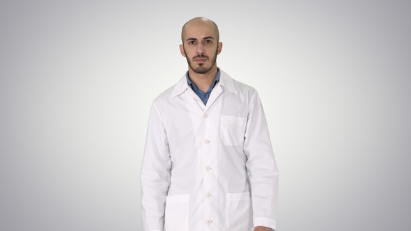 Walking male arab doctor on gradient background.