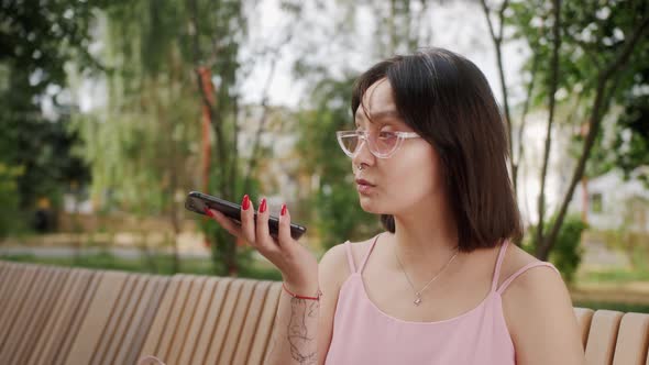 Stylish Mixed Race Young Woman Holding Phone Activate Virtual Digital Voice Assistant on Smartphone