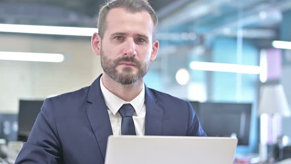 Portrait of Ambitious Businessman Looking at Camera