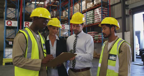 Two managers and two workers meeting in a warehouse 4k