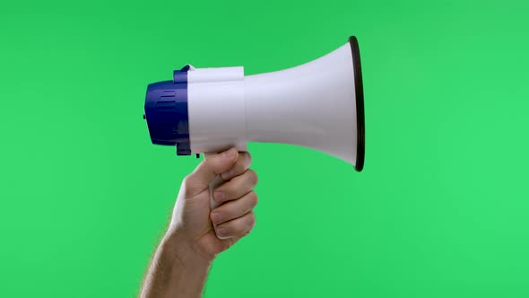 A Male Hand Raises a White Megaphone Against a Green Screen Chroma Key Background