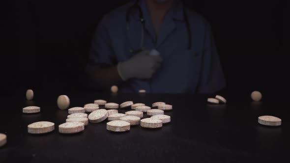 Medical Worker Pours Antiviral Pills Onto Black Surface