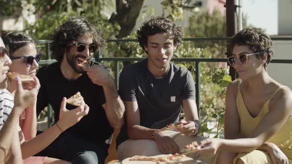 Happy People Sitting and Eating Pizza During Rooftop Party