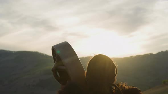 Shaman Plays Tambourine Greeting New Day in Valley at Dawn