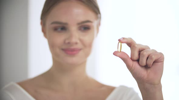 Health Supplement, Smiling Woman With Omega Pill In Hand