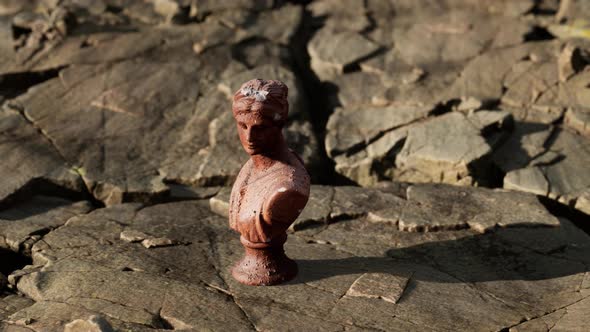 Ancient Statue of Woman on Rocky Stones alt