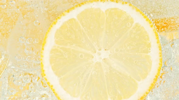 Super Slow Motion Shot of Fizzing Water with Lemon Slices and Ice Cubes in Glass at 1000 Fps