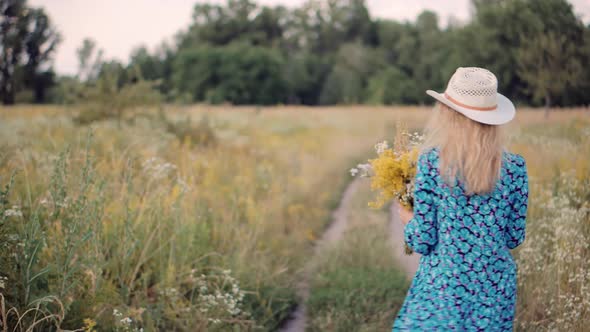 Lady In Hat Relaxing On Daisy Meadow. Chamomile Flowers Field. Happy Girl Enjoying In Green Grass.