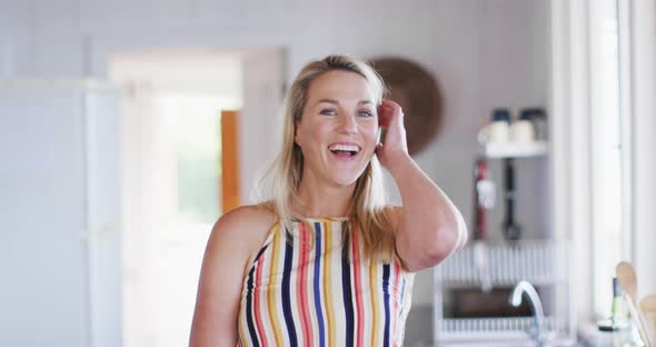 Portrait of happy caucasian mature woman smiling in the kitchen