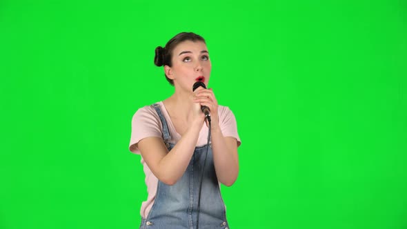 Pretty Girl Sings Into a Microphone and Moves To the Beat of Music