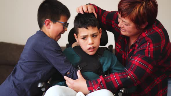 Mother Having Tender Moment with Sons at Home  Focus on Kid with Disability on Wheelchair