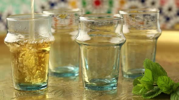 Pouring traditional Moroccan mint tea in glasses