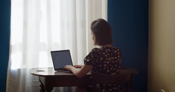 Young Woman Using Laptop Studying at Home Online