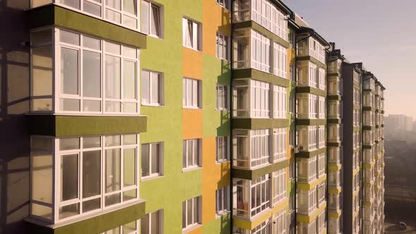 Aerial footage of a tall residential apartment building with many windows and balconies.