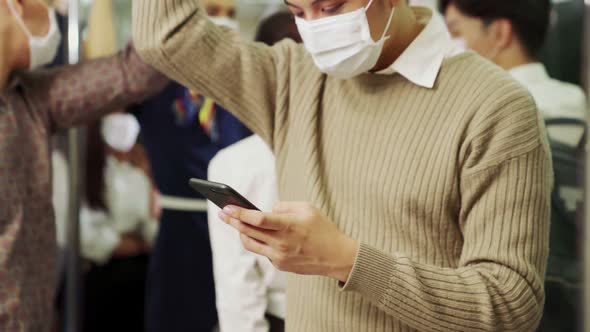 Traveler Wearing Face Mask While Using Mobile Phone on Public Train