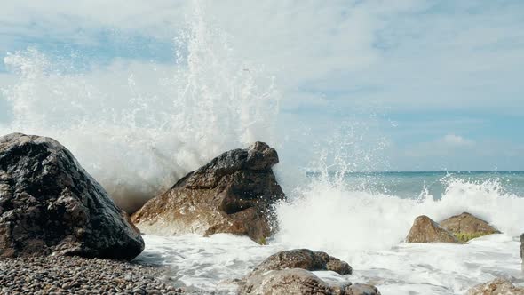 Big Wave Crashing on Stones and Spraying. Sudden Splash of Water. Waves Breaking on Stones