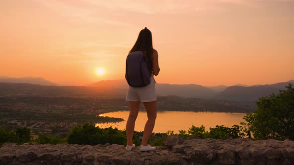 Girl at Red Sunset in the Mountains