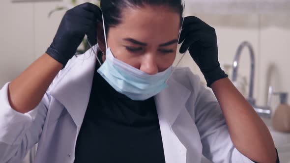 Professional Doctor Putting on Her Medical Mask While Preparation to Procedures