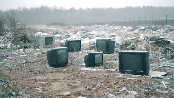 Wasted TVs During Snowfall at the Landfill Site