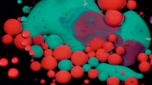 Amazing Red and Green Bubbles of Paint on the Oil Surface