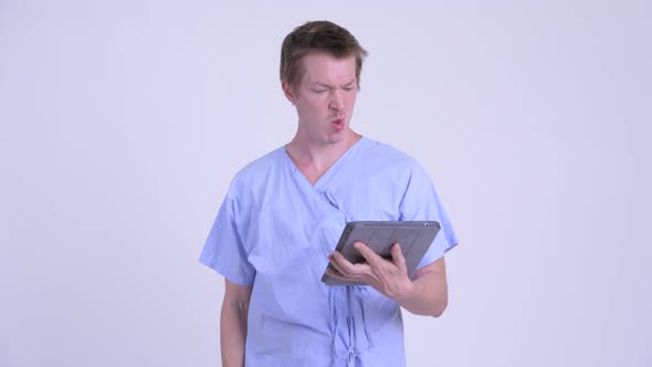 Crazy Young Man Patient Using Digital Tablet and Getting Bad News