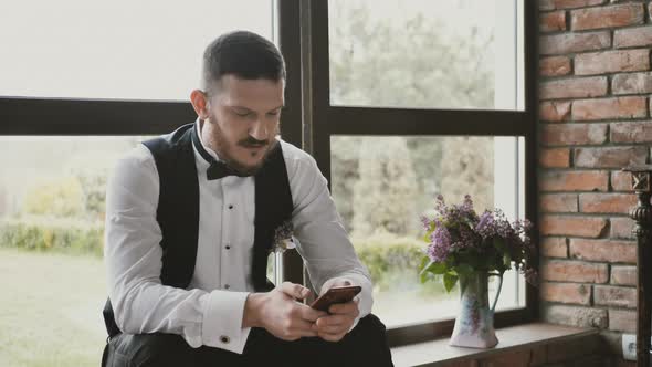 a Young Man Using a Smartphone Browses Social Networks Checks the News