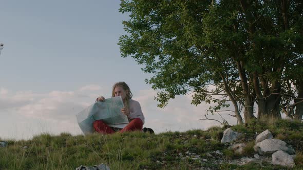 Traveler woman with dreadlocks holding tourist map on hands