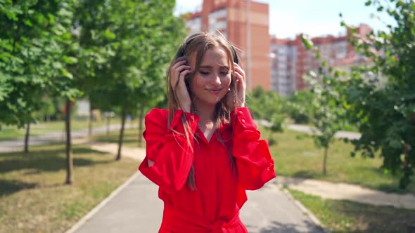 Woman listening to music on headphones. Young beautiful woman in the city with headphones listening 