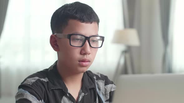 Close Up Asia Teenage Boy Learning Online From Laptop At Home