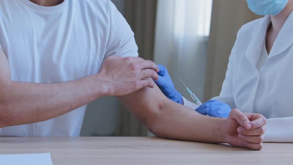 Closeup Unrecognizable Nurse Doctor in Medical Coat and Latex Gloves Giving Injection in Shoulder to