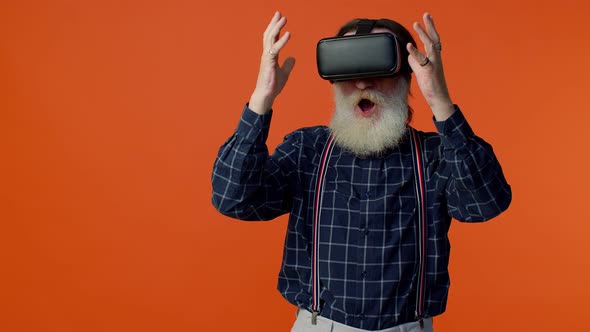 Elderly Stylish Grayhaired Man Using Headset Helmet App to Play Simulation Virtual Reality VR Game