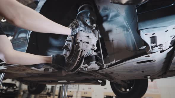 A Mechanic at a Service Station Checks the Brake and Steering Systems