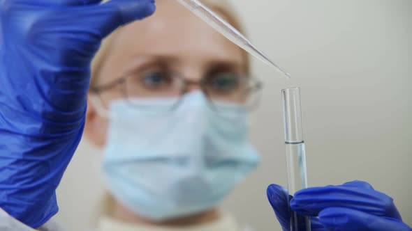 A Scientist Drips a Special Drug Into a Flask of Liquid