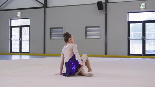 Teenage female gymnast performing at sports hall