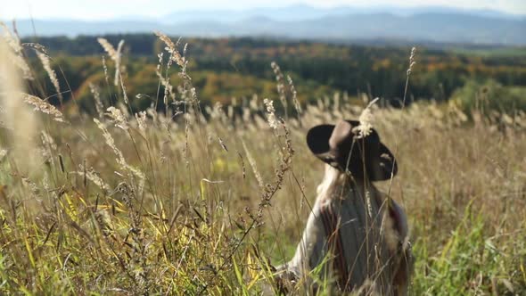 Woman in poncho at outdoor with Sudety mountains in autumn season on background