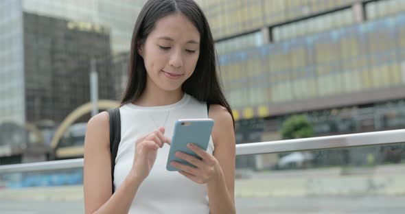 Woman typing on cellphone in city 