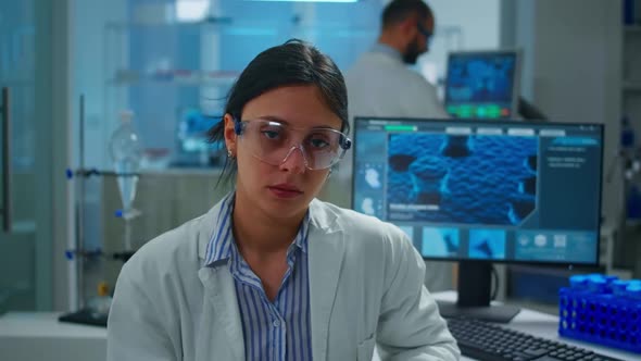 Exhausted Microbiologist with Protection Glass Looking at Camera