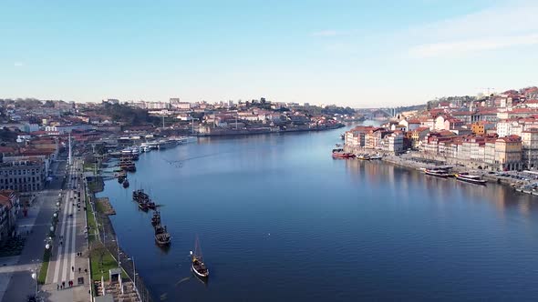 Aerial view of Douro river, Gaia and Porto river banks on a sunny day, drone going backward