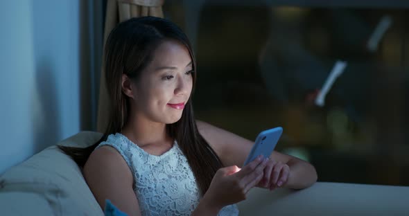 Woman look at smart phone at night