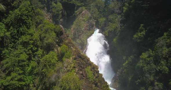 Drone image panning over a waterfall where you can see from the base to where the waterfall is born.