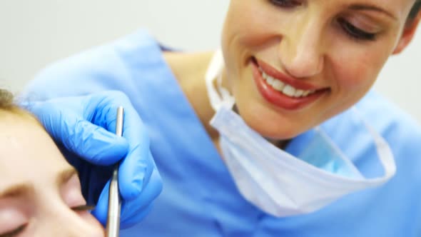 Dentists examining a young patient with tools